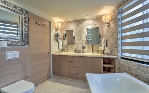 a bathroom with a tub and a toilet and a sink at Unit 135 - Beachfront Heaven Ocean Front at Terrasol in Cabo San Lucas