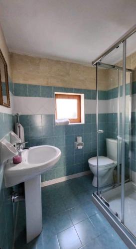 a bathroom with a sink and a toilet and a shower at Sannat Hills Farmhouse in Sannat