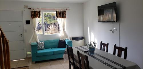 salon ze stołem i niebieską kanapą w obiekcie Lajas Del Sur w mieście Ushuaia