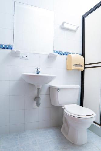 a bathroom with a toilet and a sink at Hotel Steven in Buenaventura