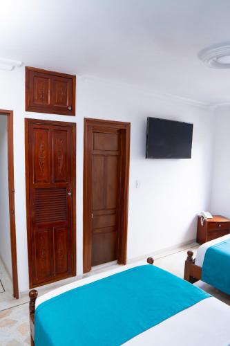a bedroom with a bed and a tv on the wall at Hotel Steven in Buenaventura