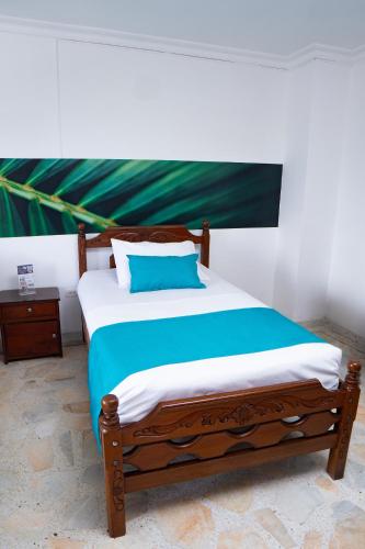 a bedroom with a wooden bed with a blue pillow at Hotel Steven in Buenaventura