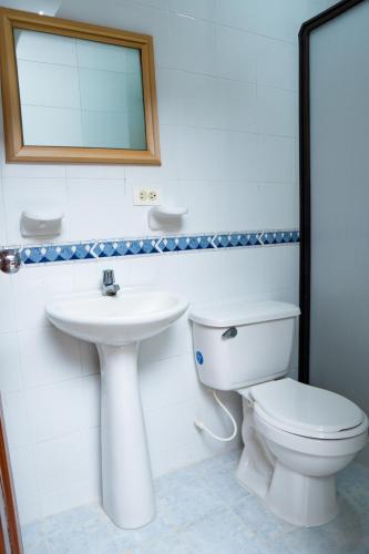 a bathroom with a toilet and a sink and a mirror at Hotel Steven in Buenaventura