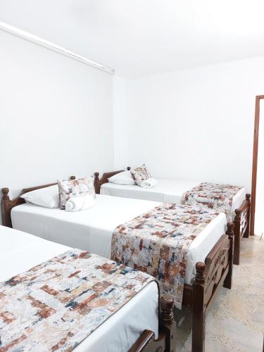 a group of three beds in a room at Hotel Steven in Buenaventura