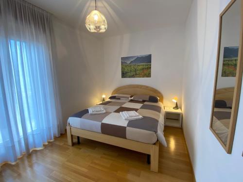 a bedroom with a bed in a room with a mirror at Casa alla Fontana in Serravalle allʼAdige