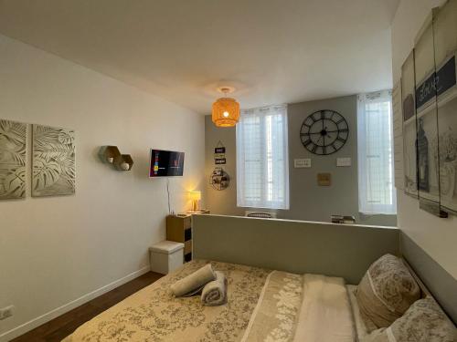 1 dormitorio con 1 cama y reloj en la pared en LE CARPE DIEM - Centre-ville - WIFI - Netflix, en Niort