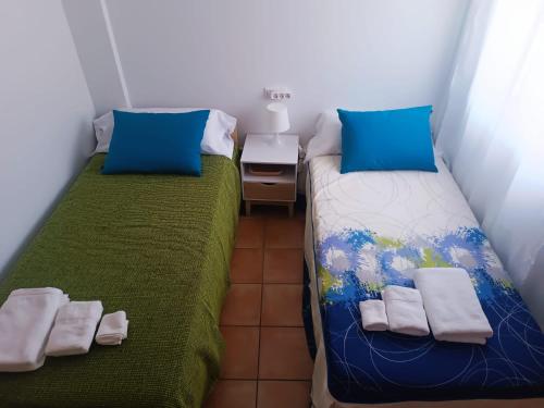 two beds in a small room with towels on them at Adosado mediterráneo in Orihuela Costa