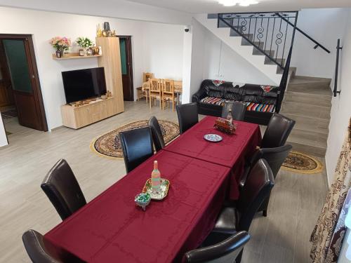 ein Esszimmer mit einem roten Tisch und Stühlen in der Unterkunft Casuta Din Livada in Moisei
