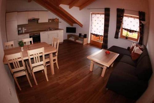 a kitchen and living room with a table and a couch at Ferienwohnung Mühl in Zwiesel