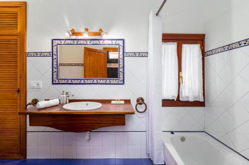 a bathroom with a sink and a tub and a mirror at Casa Velasco in Esles