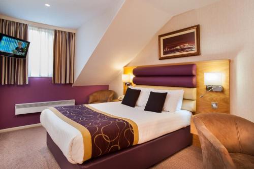 a hotel room with a large bed and a tv at Abbey Hotel Golf & Spa in Redditch