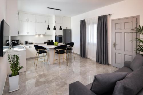 a kitchen and living room with a table and chairs at Montrez Santorini - 2 Bedroom Apartment in Mesaria