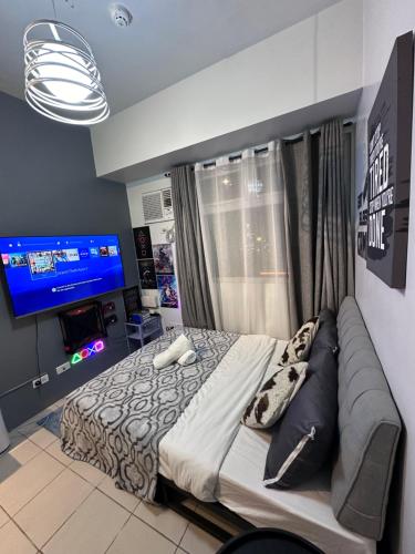 1 dormitorio con 1 cama grande y TV en Affordable Staycation Studio Rooms Edsa Shaw MRT Greenfield Near Ortigas and Pasig F Residences and Urban deca Shaw en Manila