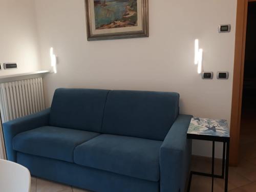 a blue couch in a living room with a table at I CACTUS di MiMa in Milano Marittima