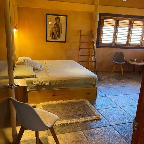 a bedroom with a bed and a chair in it at Hotel Restaurante Mi Jardin Troncones in Troncones
