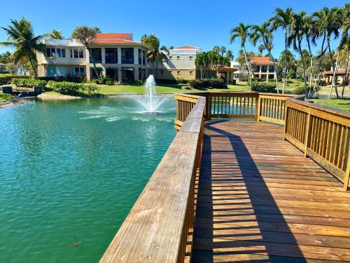 a wooden bridge over a pond with a fountain at 3 BR – Villa Coco at Lakeside Villas in Sabana