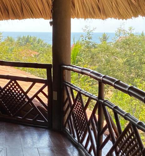 a room with a balcony with a view of the ocean at Hotel Restaurante Mi Jardin Troncones in Troncones