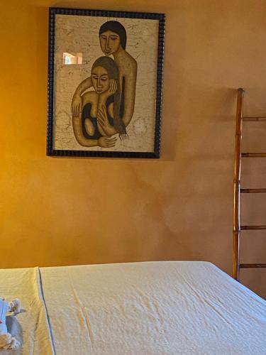 a painting of a man and a woman on a wall at Hotel Restaurante Mi Jardin Troncones in Troncones