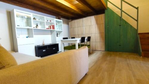 sala de estar con sofá y puerta verde en The Wooden Loft - Bari Centro, en Bari