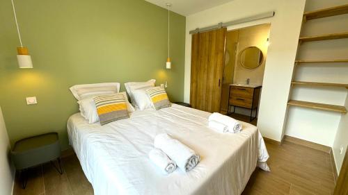 a bedroom with a large bed with white sheets and pillows at DAYA LODGE. in LʼIsle-sur-la-Sorgue