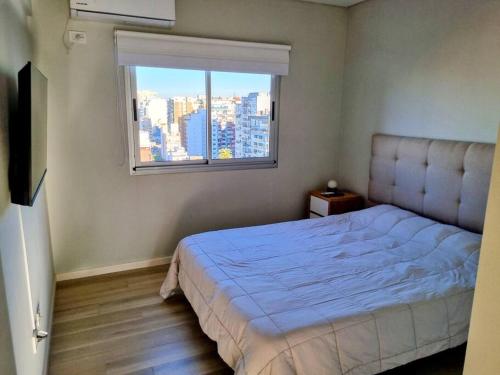 ein Schlafzimmer mit großem Bett und Fenster in der Unterkunft Rooftop Sunlight Movistar Arena in Buenos Aires