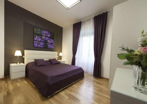 1 dormitorio con cama morada y ventana en Astoria Golden House, en Roma