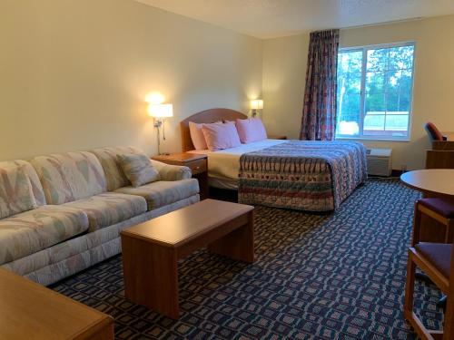 a hotel room with a bed and a couch at Budget Host Inn in Allegan