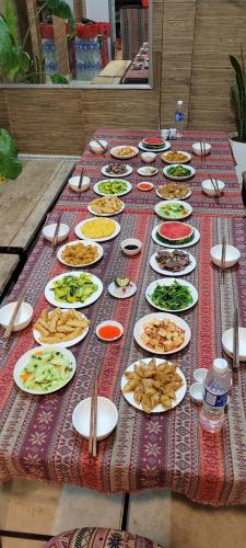 einen langen Tisch mit Teller mit Lebensmitteln drauf in der Unterkunft Du Gia View Homestay in Làng Cac