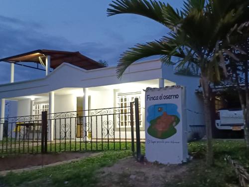 a white house with a sign in front of it at Finca el oserno in Don Rubén
