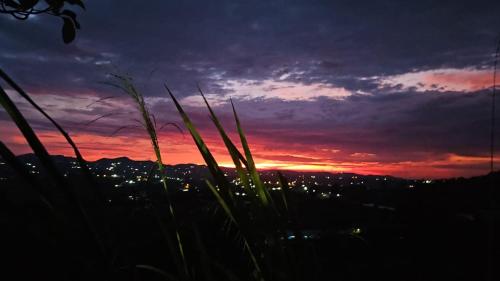 a sunset with a view of a city at Finca el oserno in Don Rubén