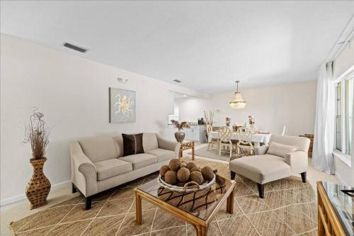 a living room with a couch and a table at Coastal Chic Home, Walk to Beach in Cocoa Beach