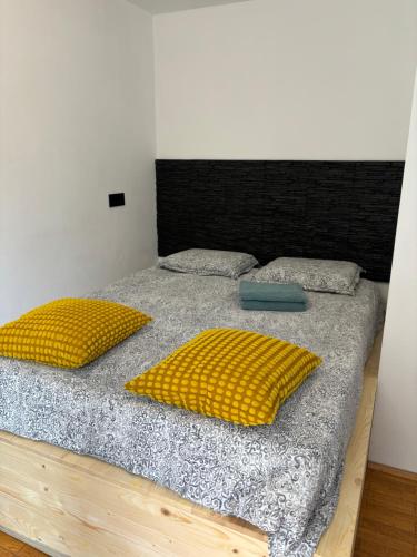 łóżko z dwoma żółtymi poduszkami na górze w obiekcie LAZY TURTLE, parking, barbecue, bicycle w Lublanie
