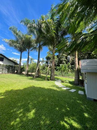 a yard with palm trees and a house at Familien Haus Pousada in Pomerode