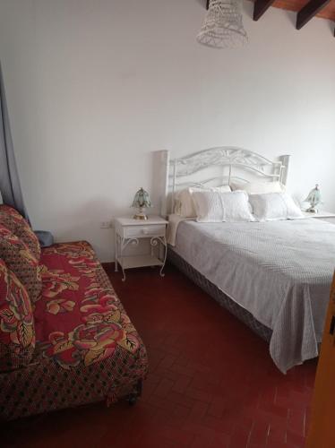 a bedroom with a large bed and a chair at Casa de la Amistad in Areguá