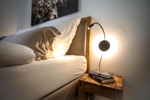 a bed with a lamp on a table next to it at Zentral - Gemütlich - Küche - Balkon - Garage in Bad Lippspringe