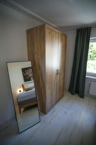 a mirror and a cabinet in a bedroom at Zentral - Gemütlich - Küche - Balkon - Garage in Bad Lippspringe