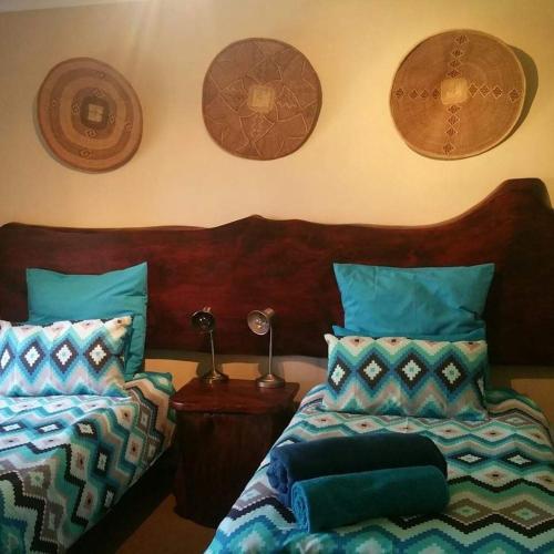 a bedroom with two beds and plates on the wall at UrbanEscape in Centurion
