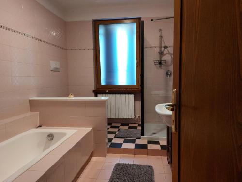 a bathroom with a tub and a toilet and a sink at Le Betulle Affittacamere in Sona