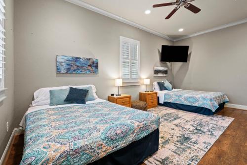 1 dormitorio con 2 camas y ventilador de techo en Luxury Waterfront Home Family and Pet Friendly Near Surfside Beach 11 Mins, en Freeport