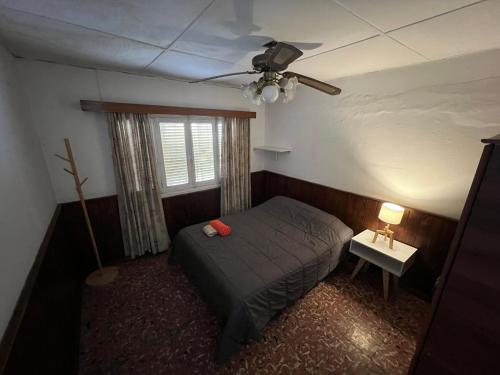 een slaapkamer met een bed en een plafondventilator bij Departamento en el corazón de Los Corralitos in Guaymallen