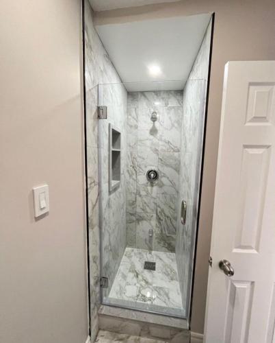 a shower with a glass door in a bathroom at Myriad Fins Cottage and Marina in Kawartha Lakes