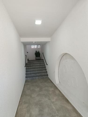 a hallway with stairs and a window and a plant at Residencial Mar Azul-suíte 12 in Pontal do Paraná