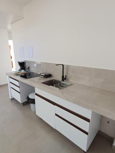 A kitchen or kitchenette at Residencial Mar Azul-suíte 12