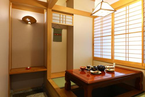 a room with a table and a window at Awanoyu in Matsumoto