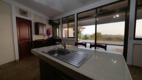 a kitchen with a sink and a large window at Casa pacific vista in Ojochal