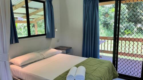 1 dormitorio con 1 cama con 2 toallas en Daintree Beach Resort, en Wonga