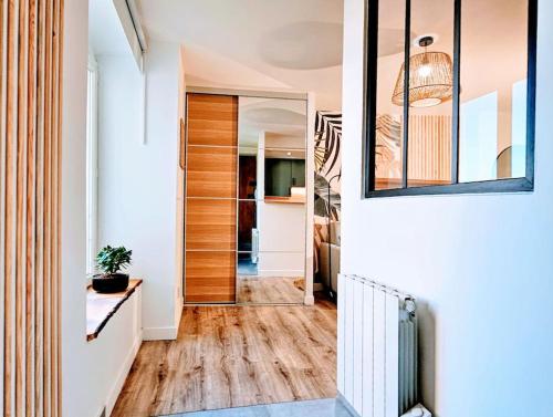 - un couloir doté de parquet et d'un miroir dans l'établissement Cocon Pure Détente Balnéo Jacuzzi, à Saint-Étienne