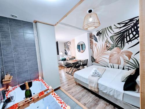 une chambre avec un lit et un salon dans l'établissement Cocon Pure Détente Balnéo Jacuzzi, à Saint-Étienne