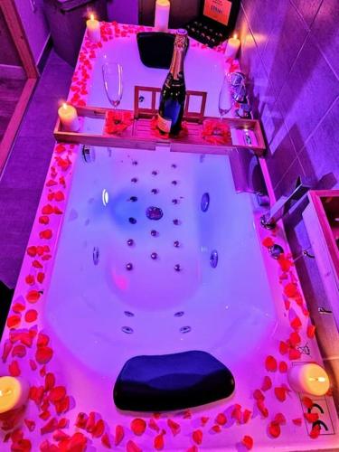 - une baignoire remplie de fleurs rouges dans la chambre dans l'établissement Cocon Pure Détente Balnéo Jacuzzi, à Saint-Étienne