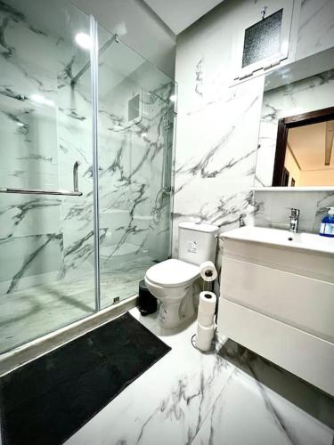 a bathroom with a shower and a toilet and a sink at SIAM’S House in El Harhoura